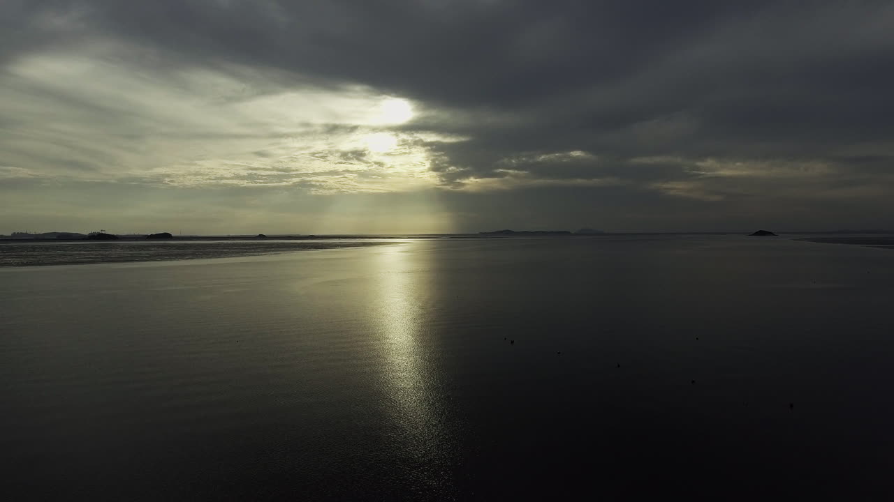 A view of the low tide of the sea at sunset, drone shot, backward