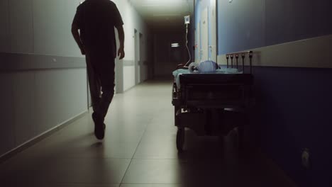 enfermera caminando por el pasillo del hospital con una camilla