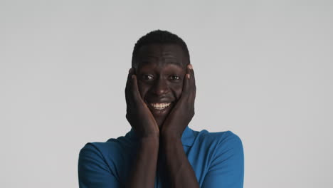 surprised african american man on grey background.