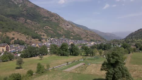 A-breathtaking-drone-ascent-reveals-a-charming-Spanish-town-nestled-amidst-the-pristine-Pyrenees-mountains-on-a-clear-and-sunny-day