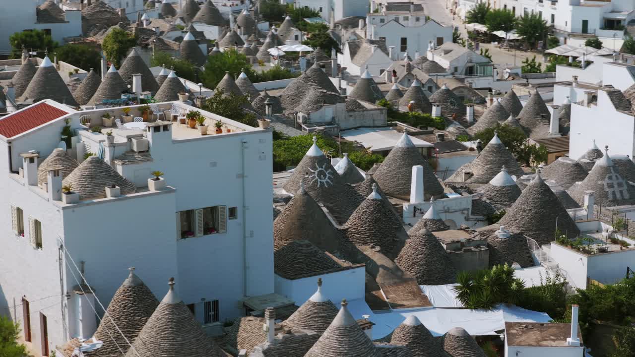 Unique conical stone roofs of trulli houses in Alberobello, UNESCO World Heritage site in Puglia, Italy. Aerial drone at low altitude