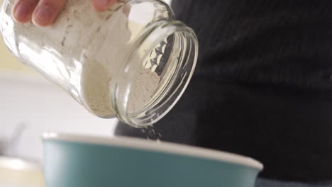 slow motion close shop as poring out the flour from a bottle into a bowl