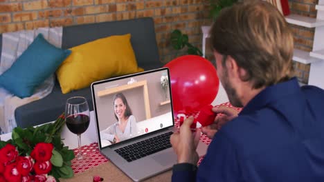 caucasian couple on a valentines date video call man showing ring to woman on laptop screen