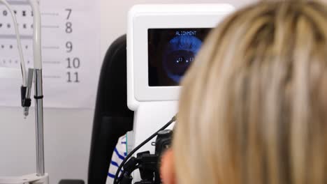 female optometrist examining young patient on coreometry