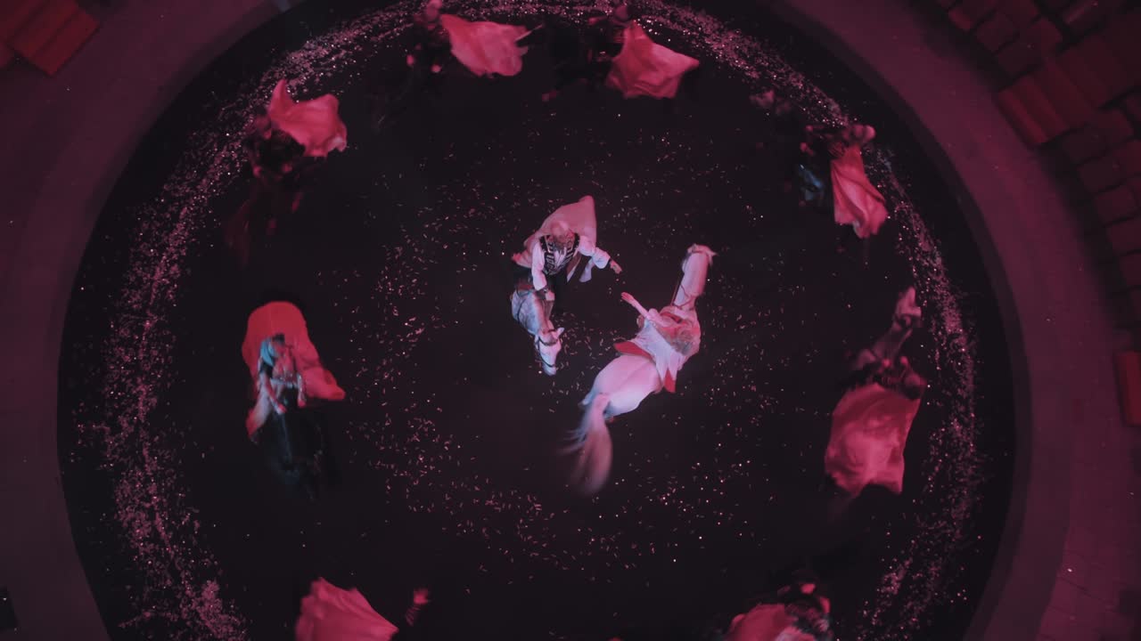 아름답고 순수한 말 위에 타고 있는 승마자들이 스포트라이트의 빛 아래 서커스 경기장을 돌아다니며 날아다니는 레인코트, 위쪽 전망