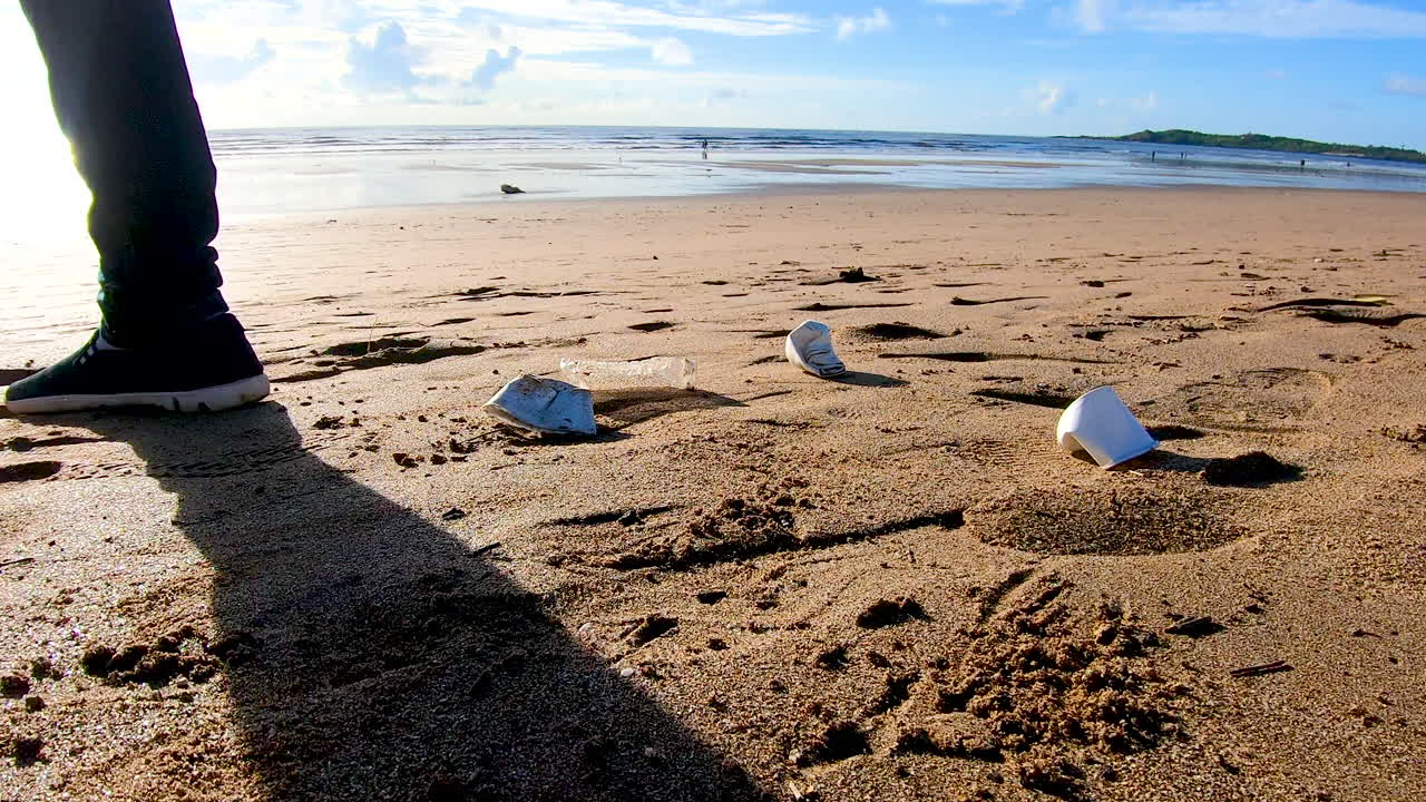 해변에 쓰레기를 던지는 관광객 남자