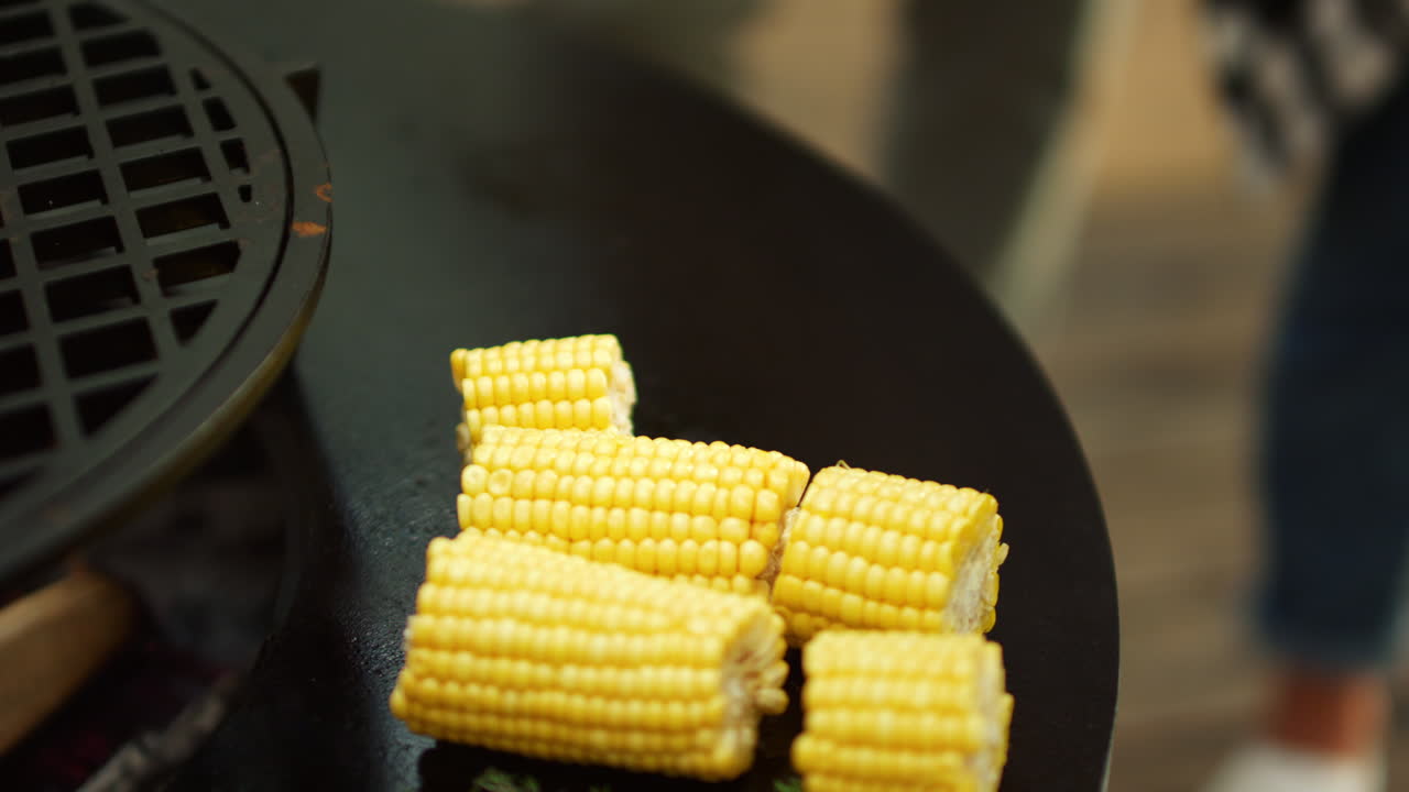 Unknown man preparing vegetarian food outside. Fresh corn grilling on bbq grill