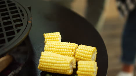 unknown man preparing vegetarian food outside. fresh corn grilling on bbq grill