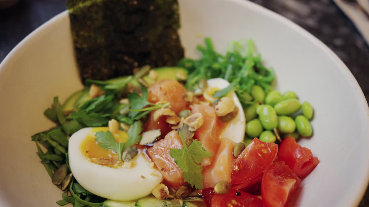 Salad salmon sehat dengan telur rebus setengah matang, alpukat, dan sayuran segar.