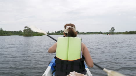 feliz joven asiática haciendo kayak en un bosque de manglares en vacaciones de verano remando en un bote de canoa en un lago forestal