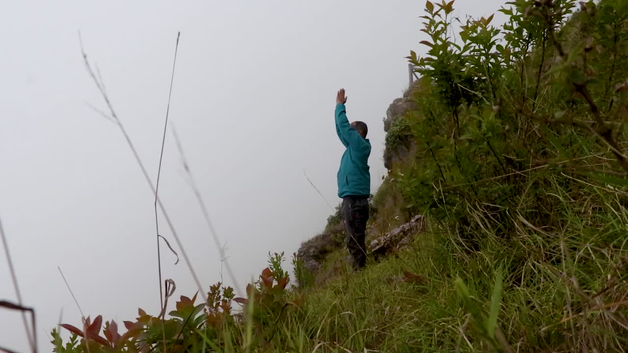 hombre haciendo yoga en la roca de la montaña con fondo de niebla blanca desde un ángulo plano
