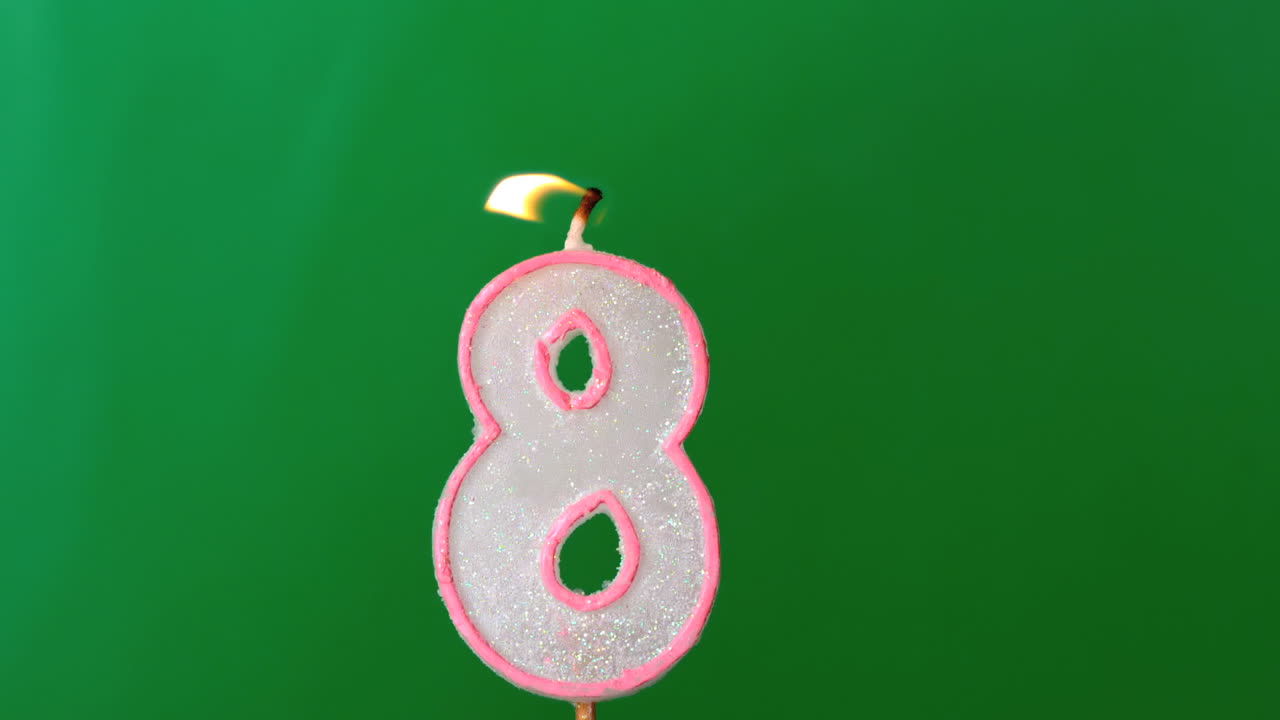 ocho velas de cumpleaños parpadeando y apagándose sobre un fondo verde