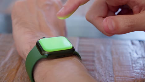 side view of a man using an apple watch while his arm is resting on a surface