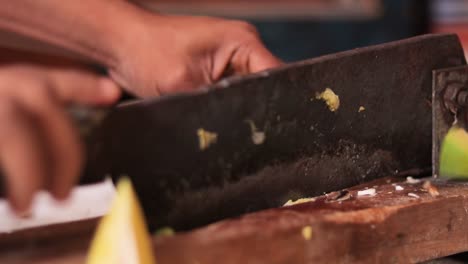 primer plano de manos cortando mango maduro para hacer pepinillos en india con cortador de verduras indio