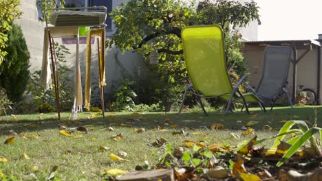 man-legs-kicking-ball-in-garden,-still-ground-level-shot