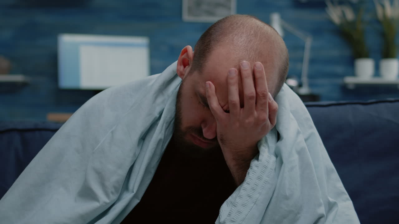 Close up of sick man blowing runny nose with tissues