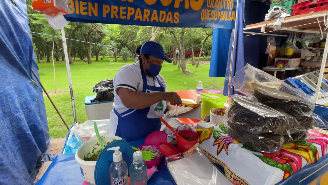 foto de un cocinero tradicional mexicano preparando tlayudas y quesadillas en el bosque de chapultepec