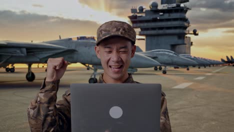 happy military personnel using laptop on aircraft carrier deck
