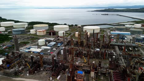 aerial pull-back shot of an aging, rusty, oil refinery