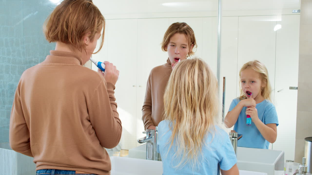 Siblings brushing teeth together