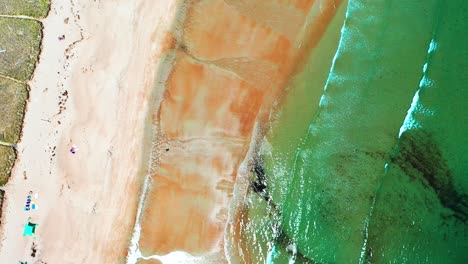 aerial bird’s-eye view drone flying straight down on crowded saco beaches in maine. vacationers enjoy sandy shores, atlantic ocean waves, and coastal homes during peak summer on the vibrant east coast