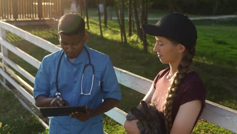 veterinario usando un dispositivo de tableta mientras habla con la niña