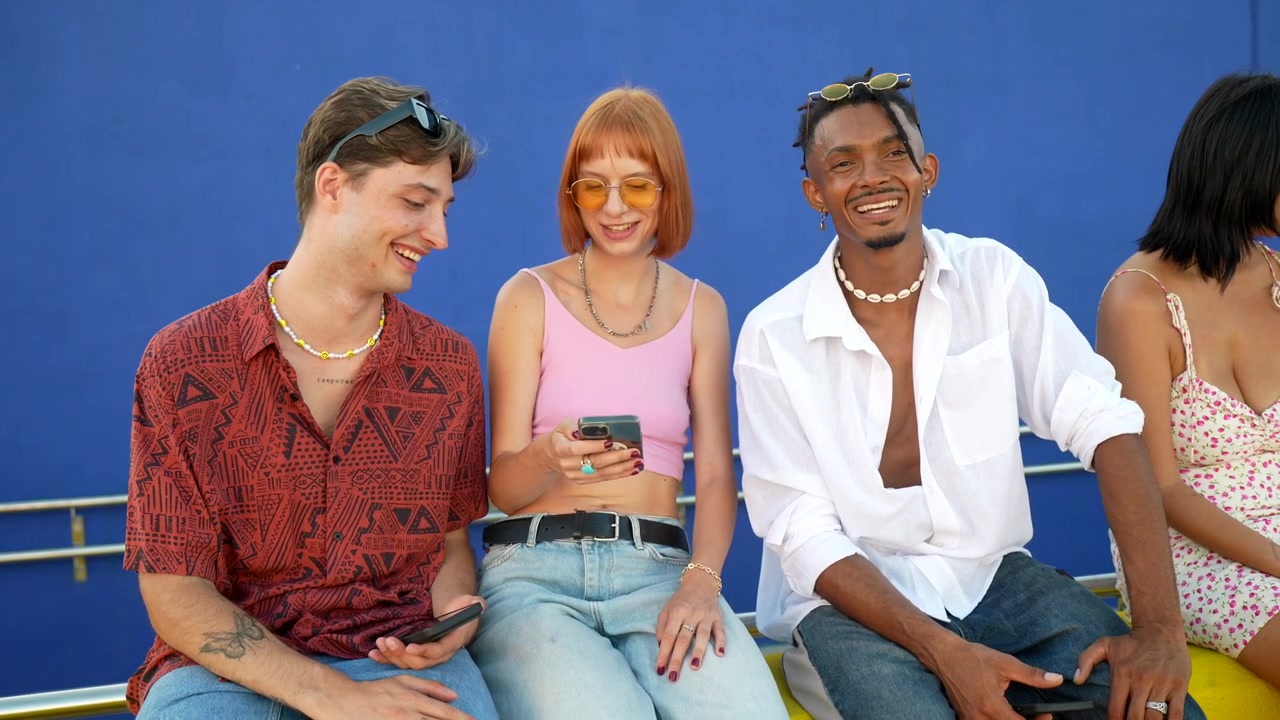 Diverse Group of Friends Using Smartphones Together Outdoors