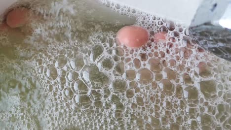 primer plano de las burbujas en la bañera de agua caliente. a través de burbujas de jabón visibles piernas persona descansando. el concepto de descanso y recreación