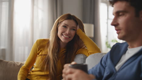 chilling spouses drinking tea at sofa interior closeup. love couple talking