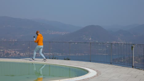 Hombre-En-Camiseta-Naranja-Grabando-Con-Estabilizador-De-Video