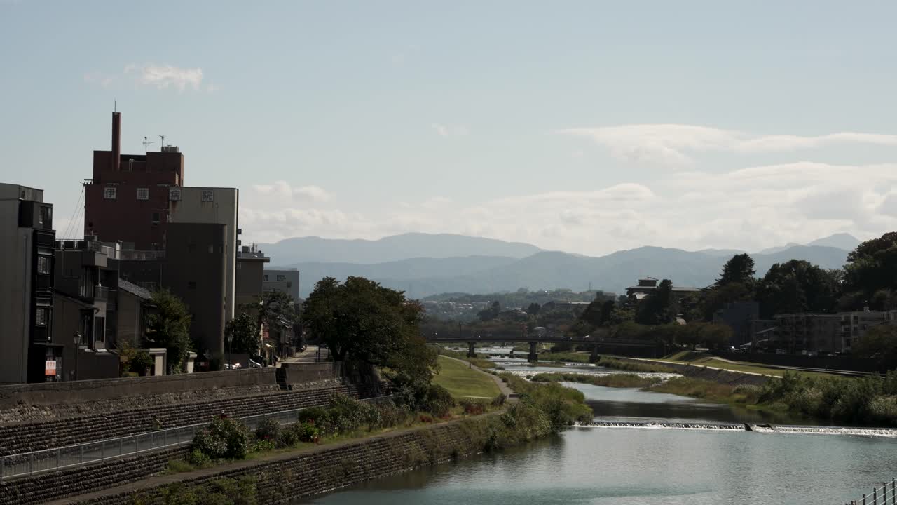 vista del río sai que fluye a través del centro de la ciudad de kanazawa por la tarde con el puente y la montaña en el fondo