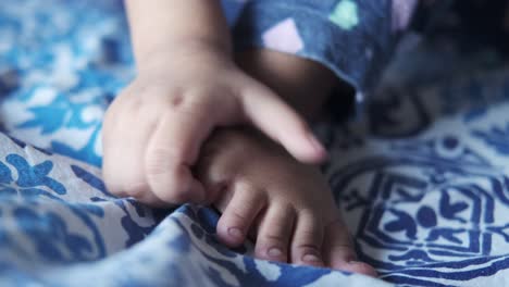 las manos y los pies del bebé en una manta azul