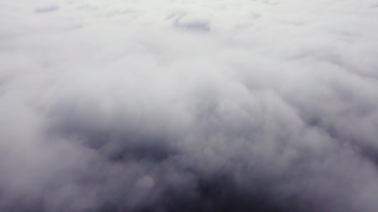 Aerial rise through fog layer into open sky, tranquil early daylight scene