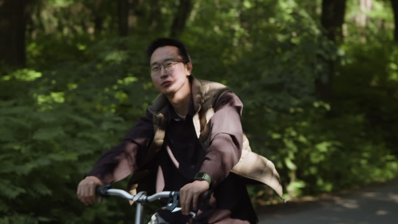 Man Riding Bicycle on Forest Road
