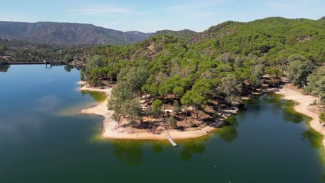 Drone-Desciende-Al-Muelle-De-Madera-En-El-Embalse-De-Encinarejo,-Paraje-Hermoso-De-La-Sierra-De-Andújar