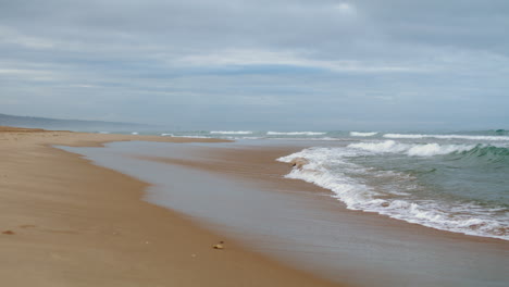 waves washing ocean shore on gloomy day vertical view. peaceful zen like spot