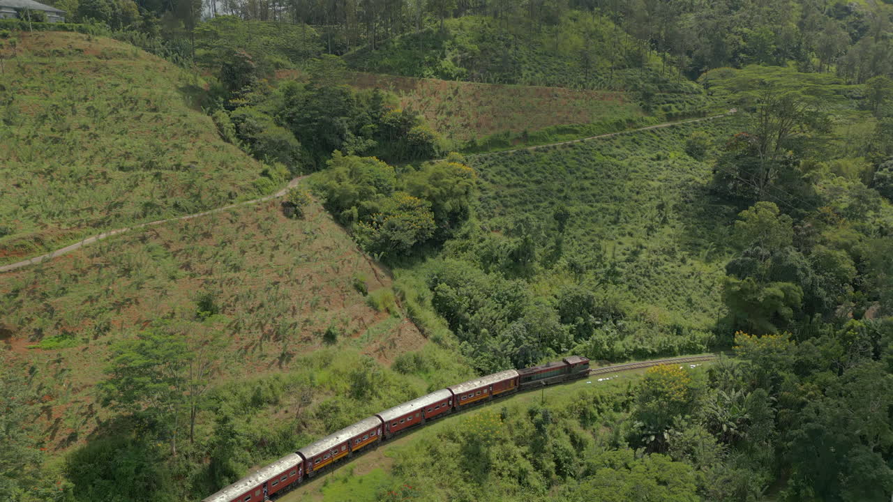 Ripresa aerea con drone di un treno passeggeri diesel nelle regioni montuose dello Sri Lanka
