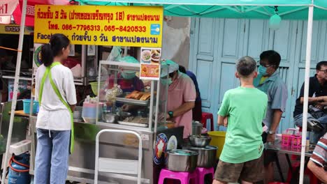 vendor interacts with customers at food stall
