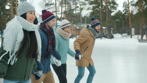 friends ice skating in winter park