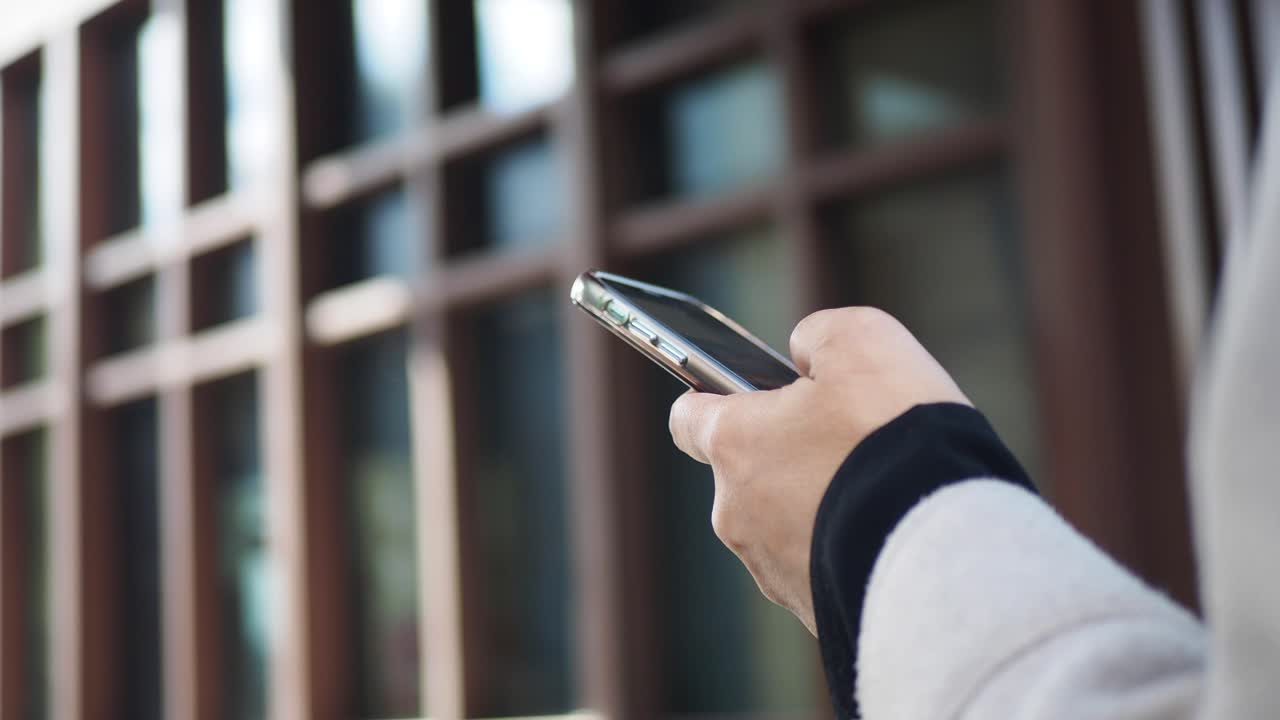 Person using a smartphone outside a building