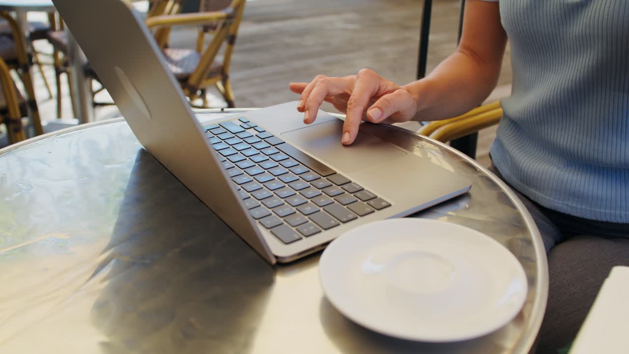 Donna che lavora al computer portatile al caffè