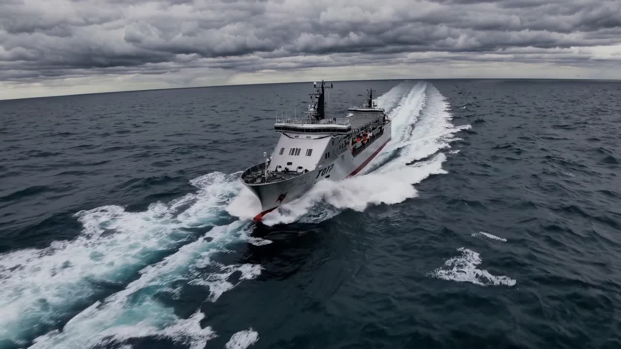 Aerial video captures a ship cutting through ocean waves under dramatic skies, emphasizing power
