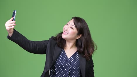 mature happy asian businesswoman taking selfie