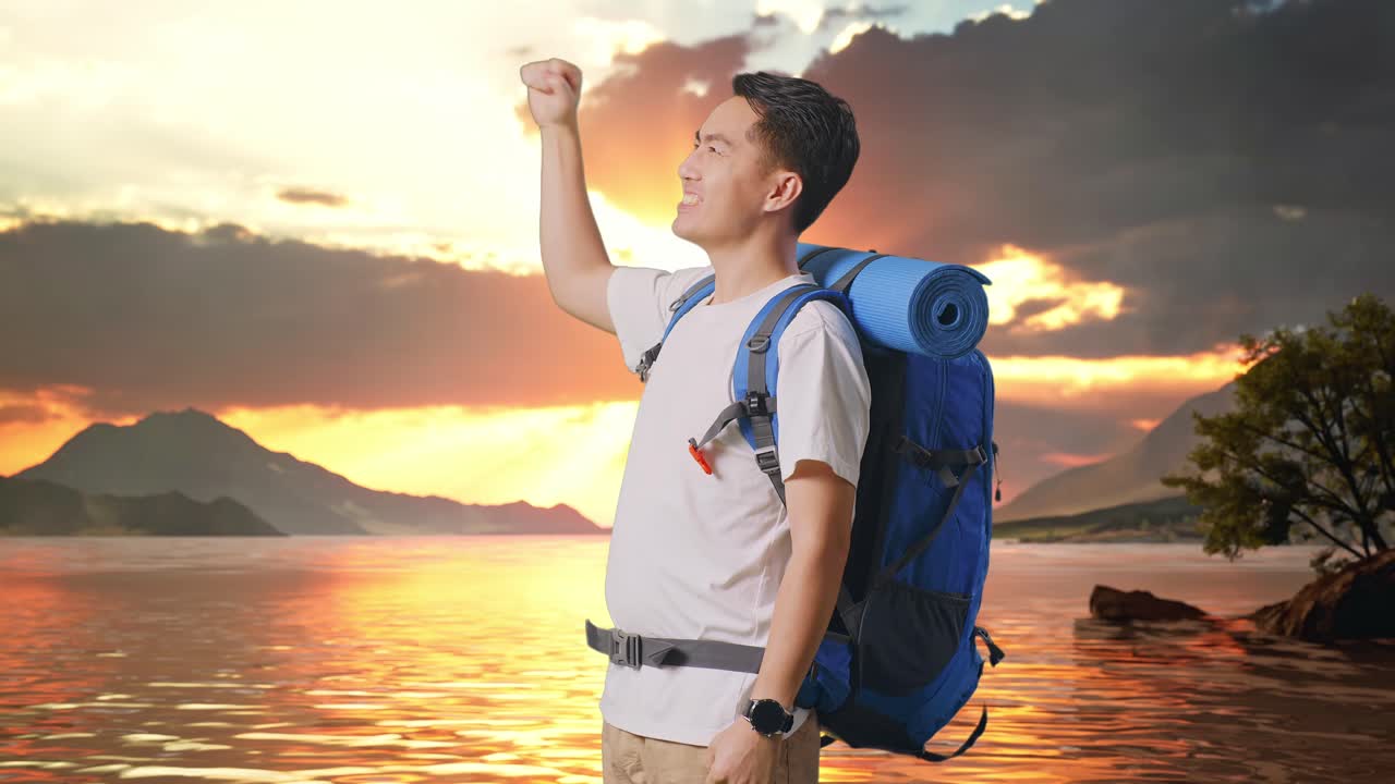 vista lateral de un excursionista masculino asiático con una mochila de montañismo gritando meta celebrando el éxito en un lago