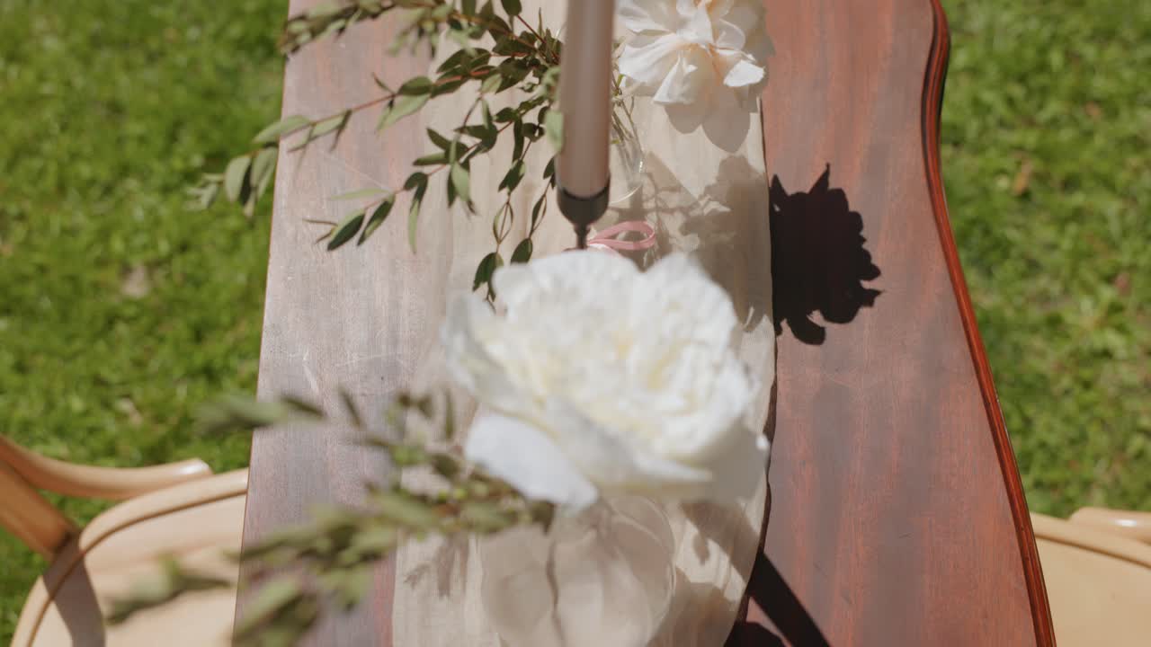 White Roses In Flower Vases With Candles In Candleholders On Wooden Table In Garden. Outdoor Wedding Venue. overhead shot