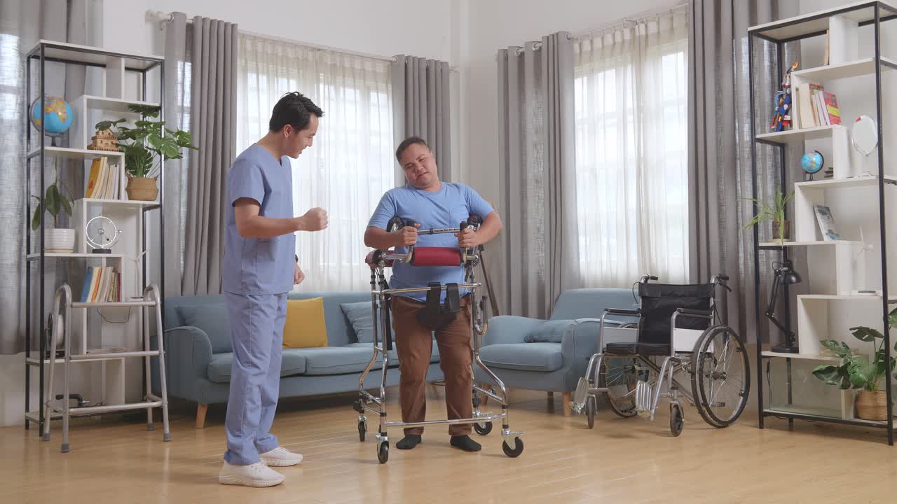 아시안 남성 간호사의 몸이 가득 차 있으며, 집에서 물리 치료를 하는 동안 발걸음으로 걸으려고 하는 환자를 격려하기 위해 손을 들어줍니다.