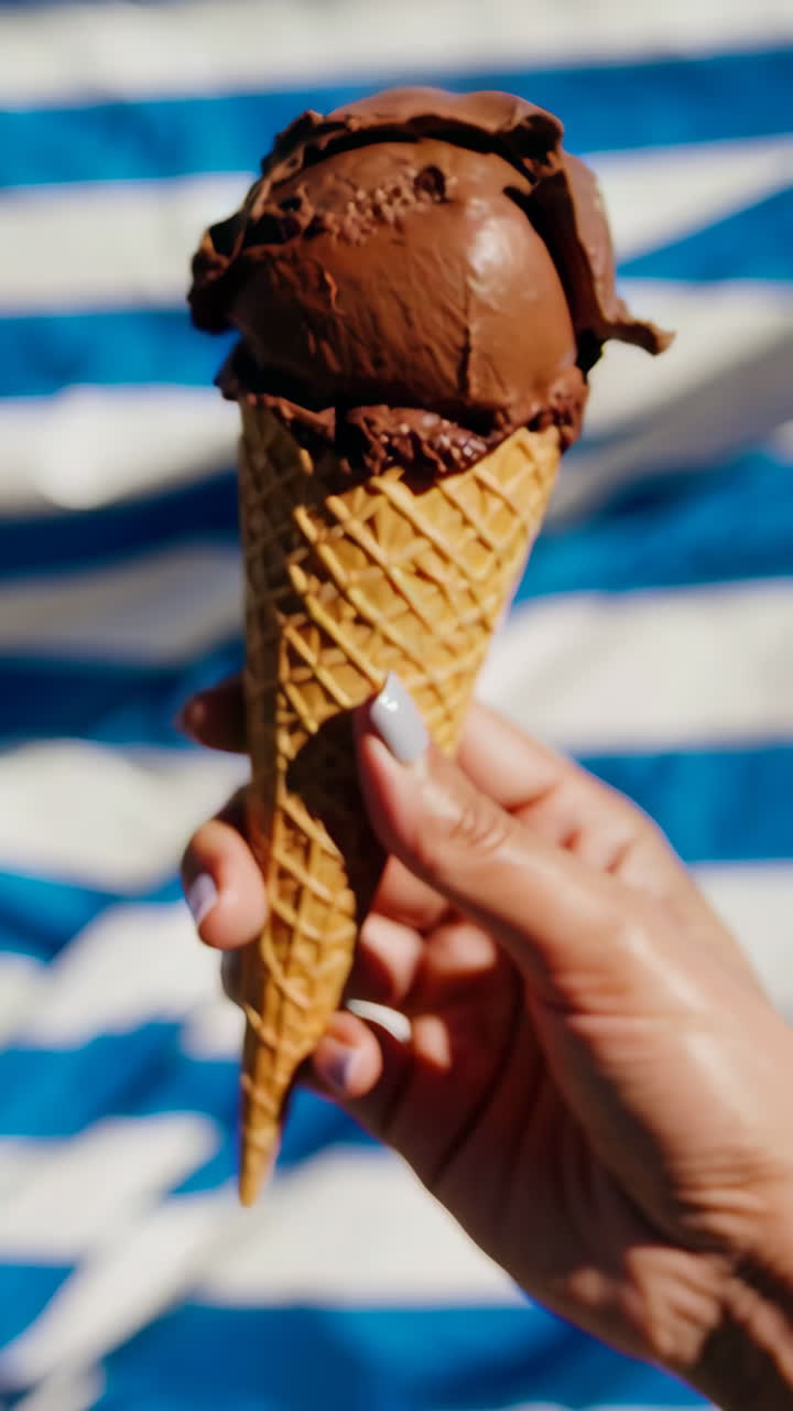 Mano che tiene un cono gelato al cioccolato