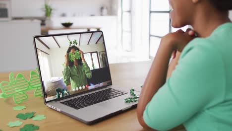 Mujer-Afroamericana-Sonriente-Con-Artículos-En-Forma-De-Trébol-En-Videollamada-En-Una-Computadora-Portátil