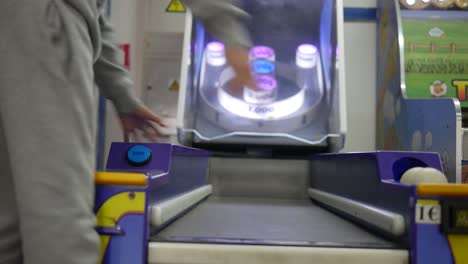 a child playing skee ball at an arcade