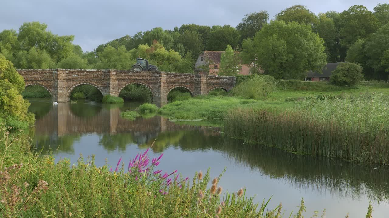 Traktor krydser White Mill Bridge over floden Stour, Dorset, England.